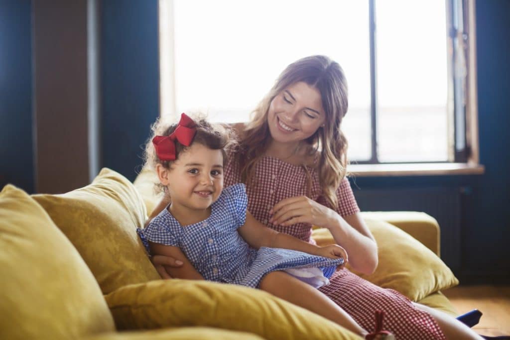 Why Stay at Home Moms Should Get Dressed Every Day featured image of a mom and her daughter dressed on the couch