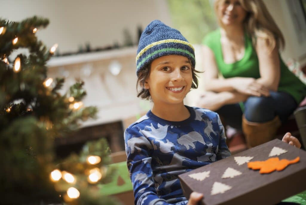 Christmas Gift Ideas for Boys - Featured image of a boy holding a Christmas gift