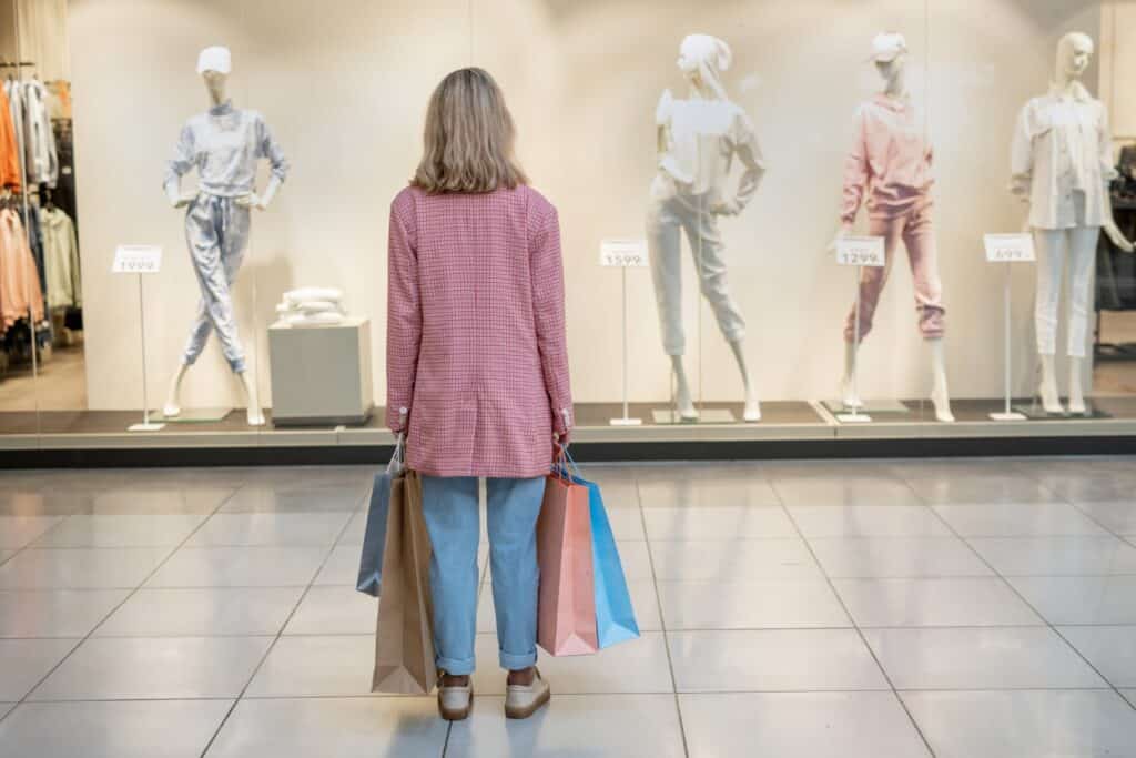 How to Dial Back Your Spending - featured image of a woman standing in a store