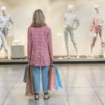 How to Dial Back Your Spending - featured image of a woman standing in a store