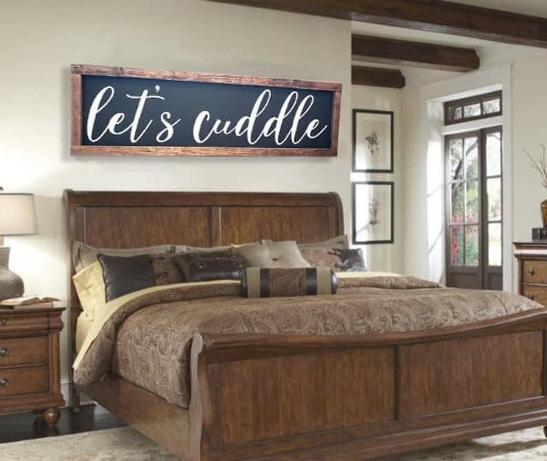 let's cuddle sign with black background, wooden frame, and white cursive font - perfect bed room decor for over the bed
