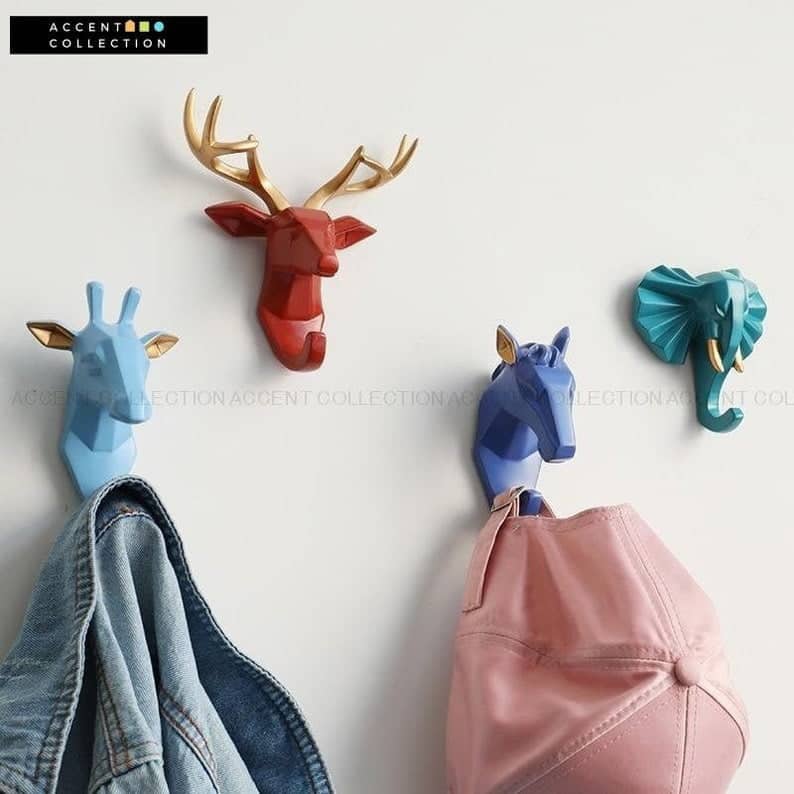 wall hooks of brightly colored geometric animal heads that have white ears or a horns. There's a deer, buck, horse, and elepant. 