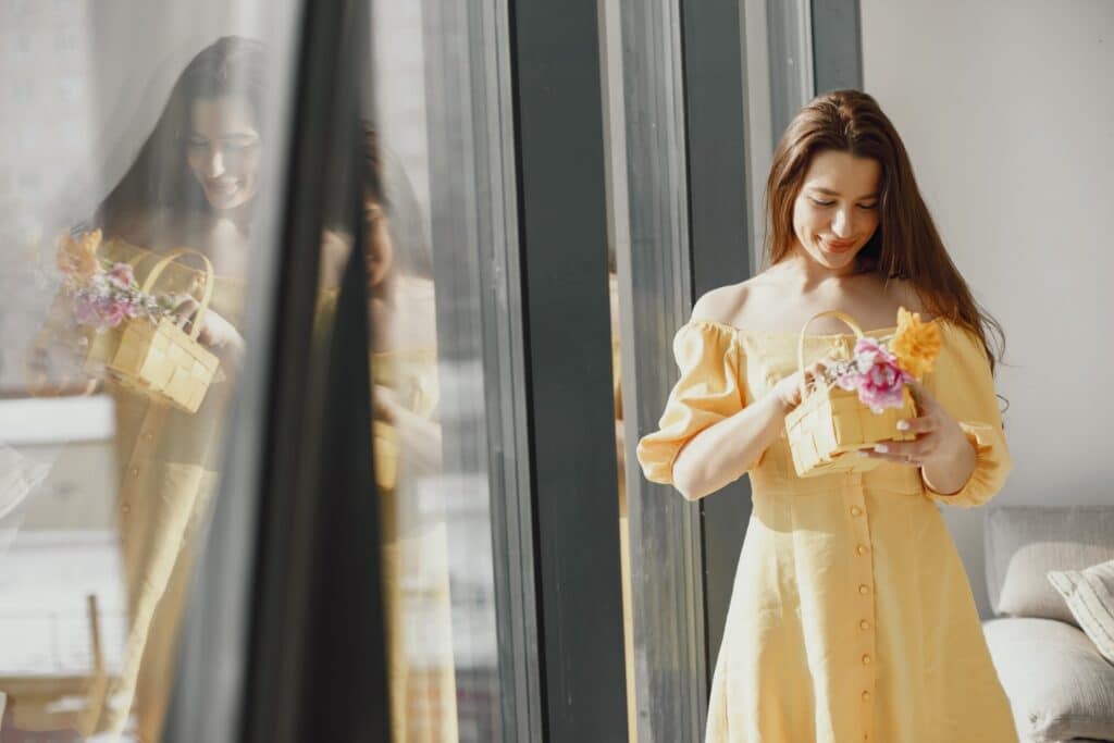 The Best Easter Dresses for Women featured image of a woman wearing a yellow dress holding an easter basket