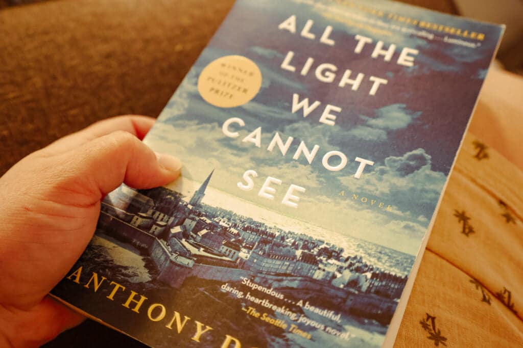 Holding my paperback copy of All the Light We Cannot See by Anthony Doerr