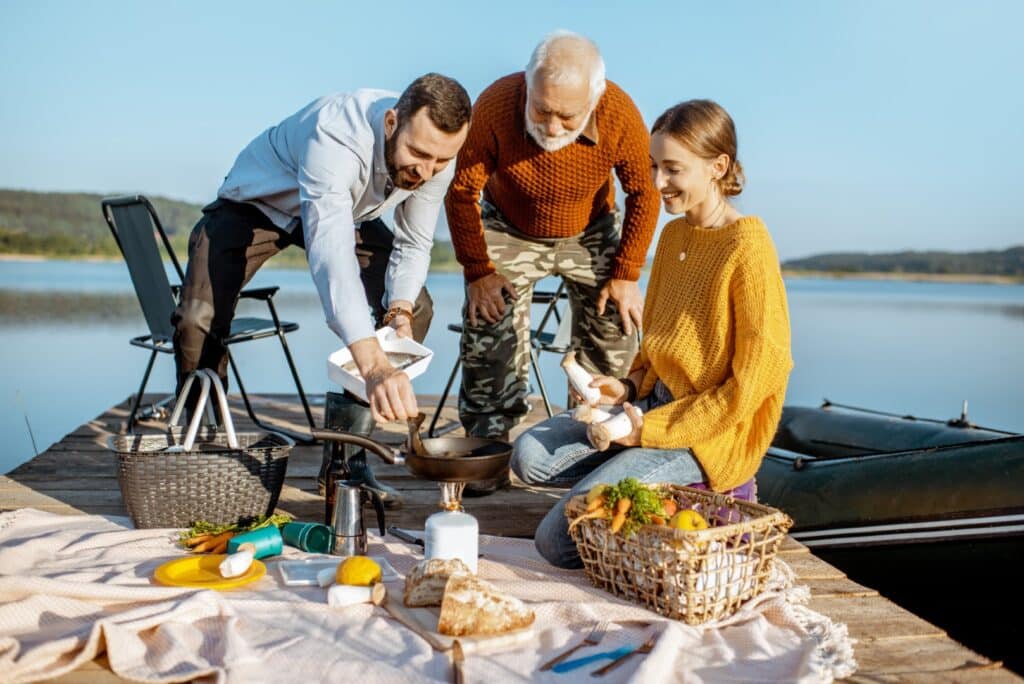 Featured image for Father's Day Gift Ideas From Adult Daughters that has an older man with a younger man and woman (his children) having a picnic