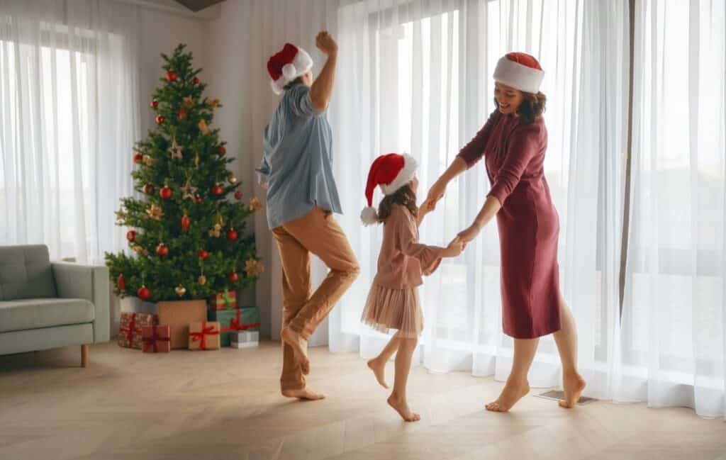 Family dancing together wearing Christmas hats