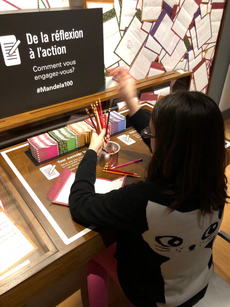 Child filling our reflection cards at an exhibit in a human rights museum.