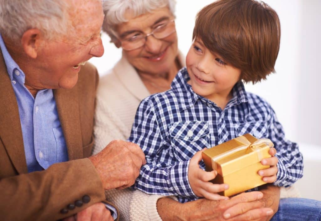 Grandparent Gift Ideas from the Kids featured image of a child giving grandparents a gift