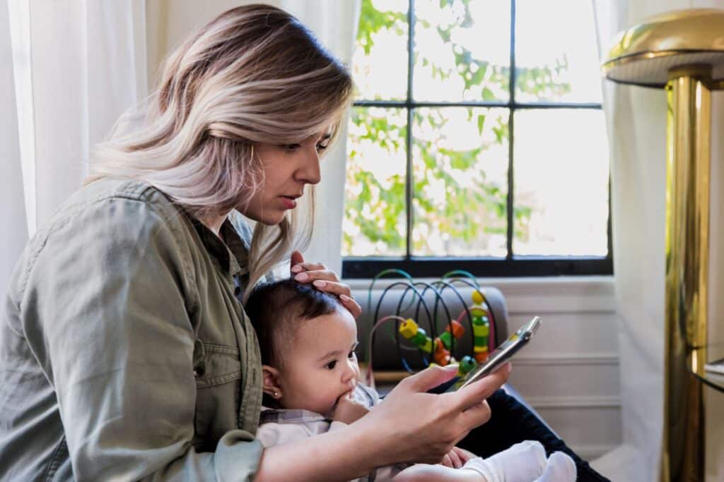 Mom on her phone while holding a baby