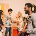 young couples exchanging christmas gifts during a Thriftmas gift exchange at home
